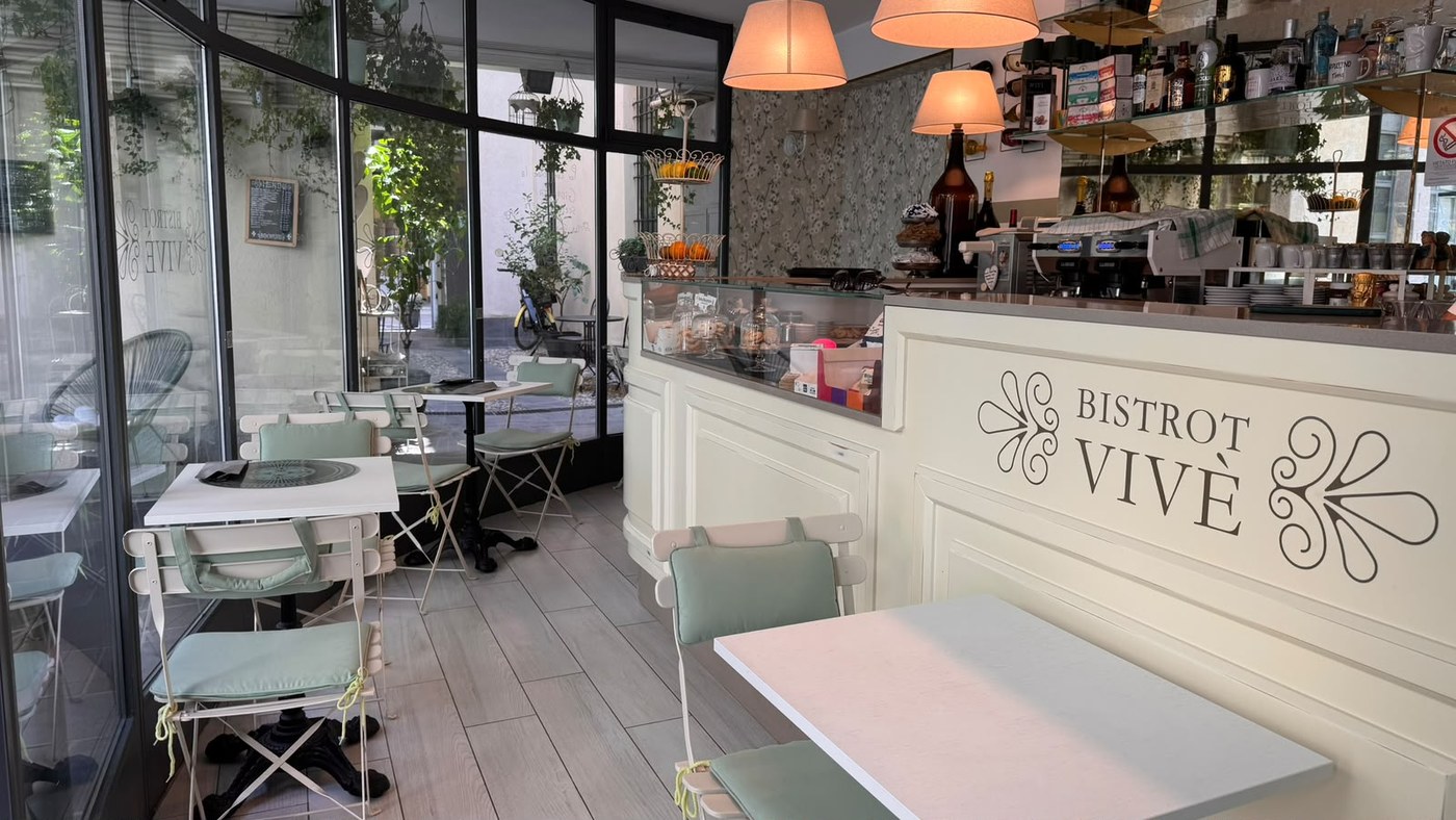 Interno del Bistrot Vivè con il bancone chiaro e l'insegna del locale
