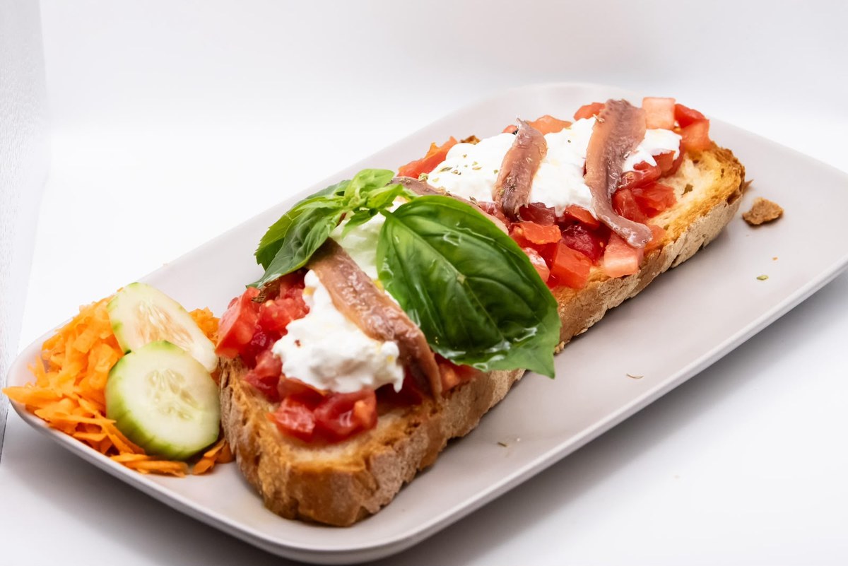Vassoio di bruschette e crostoni con pomodoro, formaggio fresco e verdure